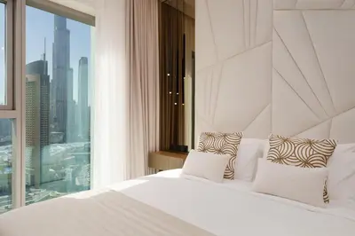 a bedroom with a white bed and a large window at Daniels 2BR at Downtown with Burj Khalifa View in Dubai