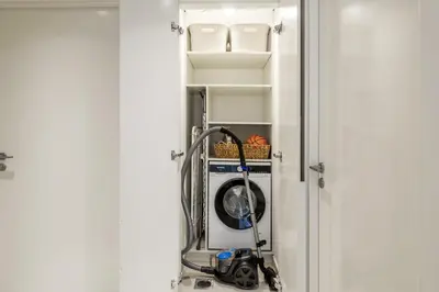 a washing machine sitting inside of a door at Daniels 2BR at Downtown with Burj Khalifa View in Dubai
