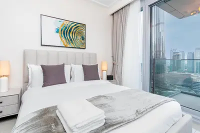 a bedroom with a large bed and a large window at WhiteSage - Opera Grand Elegance 3BR with Burj Khalifa Views in Dubai