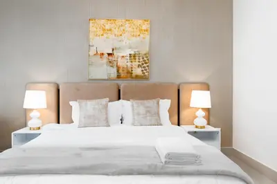 a bedroom with a large white bed with two lamps at WhiteSage - Opera Grand Elegance 3BR with Burj Khalifa Views in Dubai