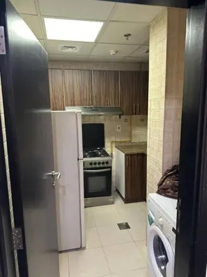 a kitchen with a stove and a refrigerator in it at Stylish 1bhk at silicon oasis in Dubai