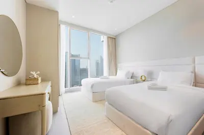 a hotel room with two beds and a large window at Stayis -Luxurious 2BR Apartment with breathtaking ocean and Marina View in Dubai