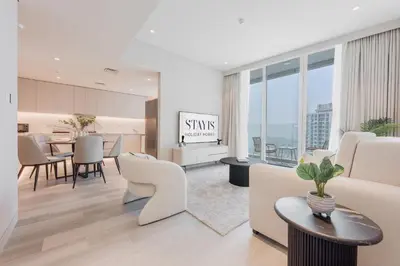 a living room with white furniture and a table at Stayis -Luxurious 2BR Apartment with breathtaking ocean and Marina View in Dubai