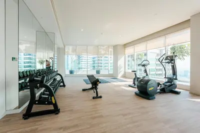 a gym with treadmills and ellipticals in a building at Stayis -Luxurious 2BR Apartment with breathtaking ocean and Marina View in Dubai
