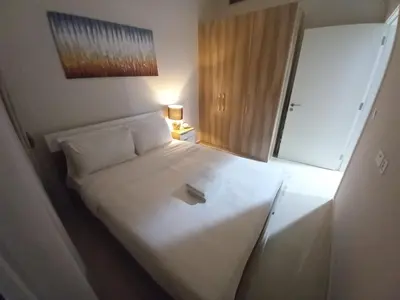 a large white bed in a small room at StoneTree - Furnished 1BR in Golf Vita A in Dubai