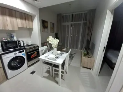 a kitchen with a table with flowers on it at StoneTree - Furnished 1BR in Golf Vita A in Dubai