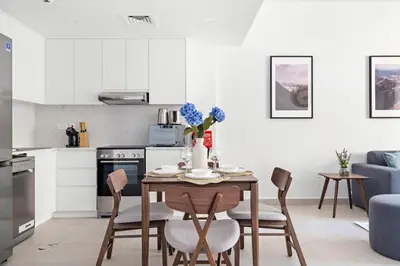 a kitchen and dining room with a table and chairs at StoneTree - Furnished 1BR in Madinat Jumeirah in Dubai