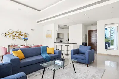 a living room with a blue couch and two chairs at Luxury 1BR - Leisure Facilities Access - Sea View in Dubai