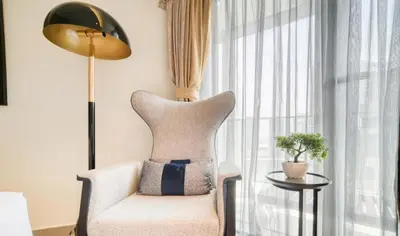 a living room with a chair and a lamp at Luxury Hotel Apartment - DownTown in Dubai