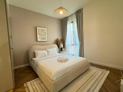 a bedroom with a large white bed with a window at Oraya - Brand New Luxurious 3BR plus 2M Villa in Maple 2 in Dubai