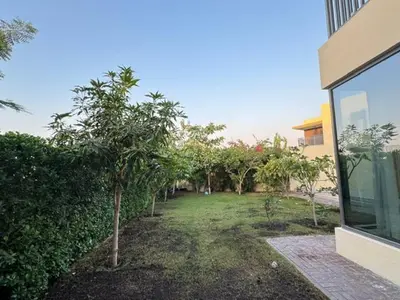 a yard with trees in front of a building at Oraya - Brand New Luxurious 3BR plus 2M Villa in Maple 2 in Dubai