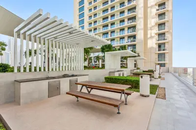 a patio with a bench and a table and a building at Luxurious Living in the heart of Emaar Beachfront in Dubai