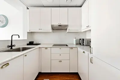 a white kitchen with white cabinets and a sink at StoneTree - Furnished 1BR in JLT with Lake View in Dubai