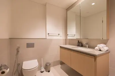 a bathroom with a toilet and a sink and a mirror at Creek Beach Roomy 3BR + terrace in Dubai