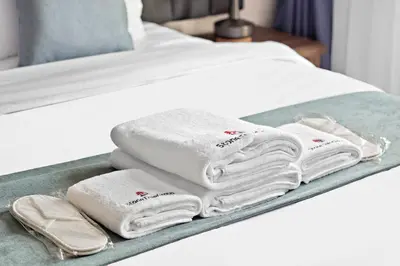 a tray with towels on a bed at StoneTree - Luxury 1BR - Best Location for Tourist in Dubai