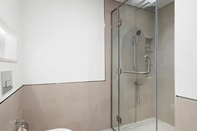 a shower with a glass door in a bathroom at StoneTree - Luxury 1BR - Best Location for Tourist in Dubai