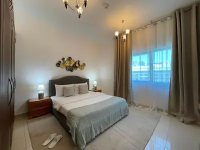 a bedroom with a bed and a large window at Home Away From Home - Barsha Heights in Dubai