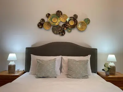 a bedroom with a bed with two lamps and areath on the wall at Home Away From Home - Barsha Heights in Dubai