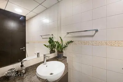 a bathroom with a sink and a mirror at Your Cosy Marina Retreat in Dubai