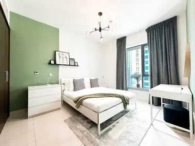 a bedroom with a white bed and a green wall at Trophy - 29 Boulevard Tower Downtown Suite in Dubai