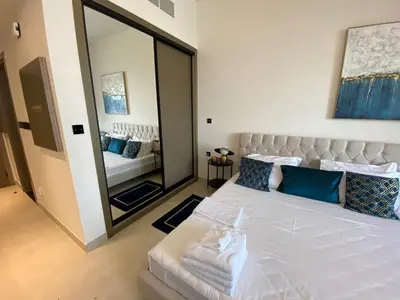 a bedroom with a large mirror and a bed at White and gold studio apartment in Binghatti Canal whit pool in Dubai