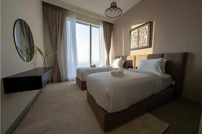 a hotel room with two beds and a mirror at Oraya - Chic 2BR Apt in Downtown Dubai With City Views in Dubai