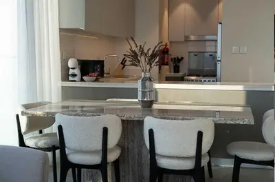 a kitchen with a counter with a table and chairs at Oraya - Chic 2BR Apt in Downtown Dubai With City Views in Dubai
