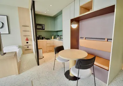 a small kitchen with a table and chairs in a room at Studio with Burj Khalifa View - Upside Living in Dubai