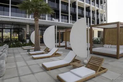 a row of chaise lounges and chairs on a patio at Studio with Burj Khalifa View - Upside Living in Dubai