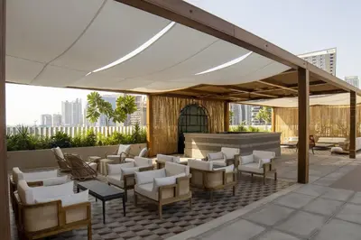 a patio with a white canopy and chairs and tables at Studio with Burj Khalifa View - Upside Living in Dubai