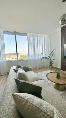 a living room with a couch and a table at LUXURY SPACIOUS - 1 BR - SKY GARDENS DIFC - Heart of Trade Centre and Dubai Mall in Dubai