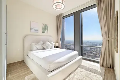 a bedroom with a white bed with a large window at Visionary Vista: 2BR Al Habtoor City in Dubai