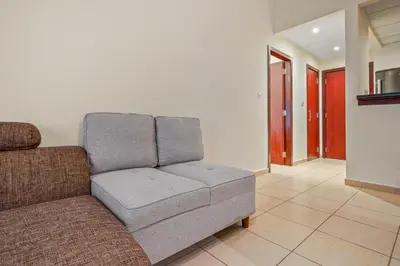 a couch sitting in a living room at Cozy pad in the heart of Dubai on JBR beach! in Dubai