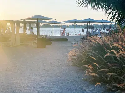 a beach with umbrellas and people on the beach at Seven Palm, Private beach, Infinity Pool, High Floor 3BDR in Dubai
