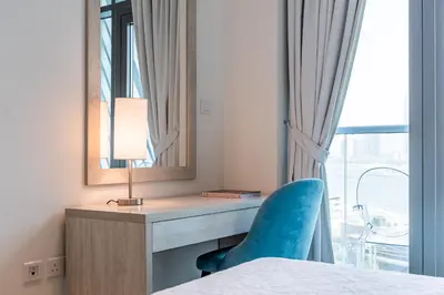 a bedroom with a desk with a blue chair and a mirror at Seven Palm, Private beach, Infinity Pool, High Floor 3BDR in Dubai