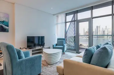a living room with blue chairs and a large window at Seven Palm, Private beach, Infinity Pool, High Floor 3BDR in Dubai