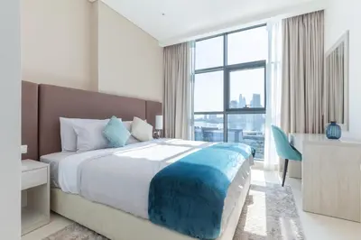 a bedroom with a bed and a desk and a window at Seven Palm, Private beach, Infinity Pool, High Floor 3BDR in Dubai