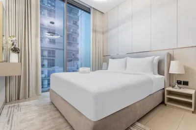 a bedroom with a large white bed and a window at STAY BY LATINEM Luxury 1BR Holiday Home CVR A1504 near Burj Khalifa in Dubai