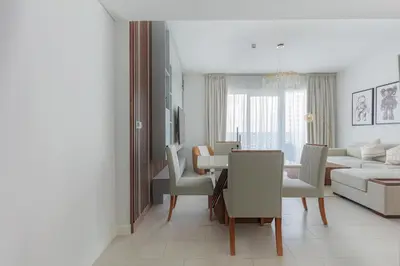 a white living room with a table and a couch at La Vie, JBR private beach, private parking and pool in Dubai