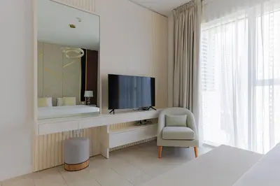 a bedroom with a tv and a chair and a mirror at La Vie, JBR private beach, private parking and pool in Dubai