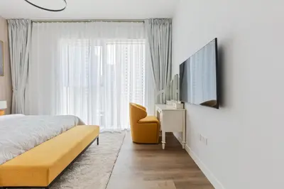 a bedroom with a bed and a flat screen tv at La Vie, JBR private beach, private parking and pool in Dubai