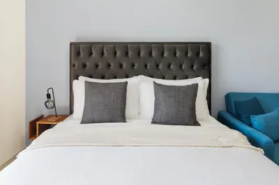a bedroom with a large bed and a blue couch at Modern Studio Sports City Pool & City Views in Dubai