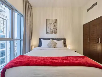 a bedroom with a large bed with a red blanket at Golden Homes Boulverd Central 1BHK BLUE HEAVEN Near Dubai mall & burj khalifa Downtown Dubai in Dubai