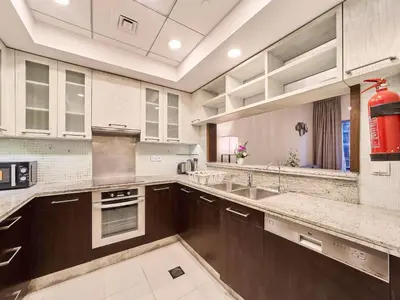 a large kitchen with brown cabinets and a sink at Golden Homes Boulverd Central 1BHK BLUE HEAVEN Near Dubai mall & burj khalifa Downtown Dubai in Dubai