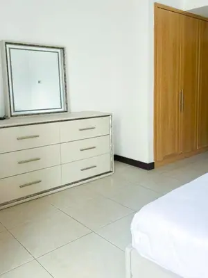 a white bedroom with a dresser and a window at Full lake View 1bk Apartment in JLT 4 ppl early & late check in 10mn to Marina metro station in Dubai