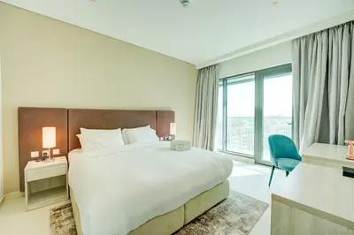 a bedroom with a large bed and a large window at Seven Palm 1 Bed with Rooftop Infinity Pool in Dubai