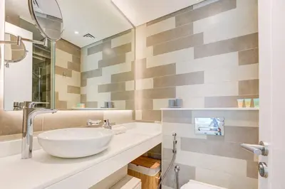 a bathroom with a white sink and a mirror at Seven Palm 1 Bed with Rooftop Infinity Pool in Dubai