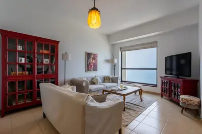 a living room with a couch and a tv at JBR High Floor 2 Bed with full Al Ain View in Dubai
