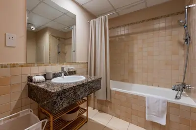 a bathroom with a sink and a tub and a mirror at JBR High Floor 2 Bed with full Al Ain View in Dubai