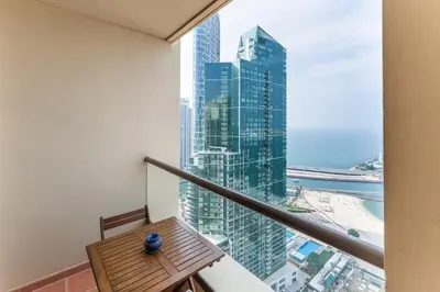 a balcony with a table and a view of a city at JBR High Floor 2 Bed with full Al Ain View in Dubai